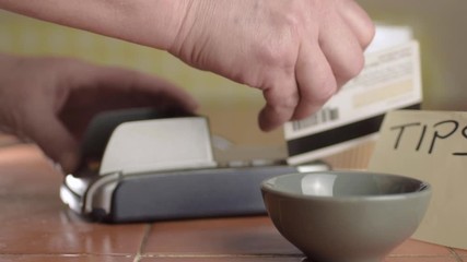 Hands  swiping credit card in restaurant