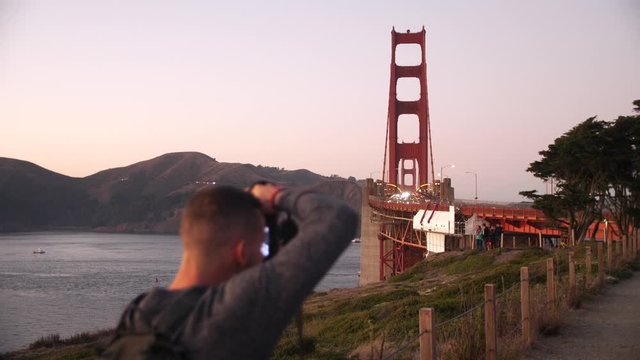 4k slow motion video of photographer making pictures of the golden gate bride at sunset - Places to see in San Francisco - Tourist destination California - Professional photo camera