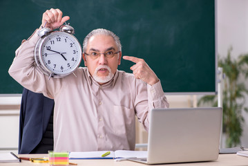 Old male teacher in the classroom