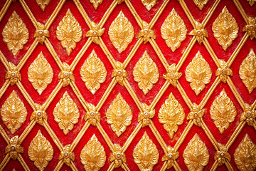 Traditional Thai style Pattern style stucco art.The plaster mold is a golden Thai pattern of flowers Decorate on the red floor. Popularly installed according to tourist attractions in the temple.