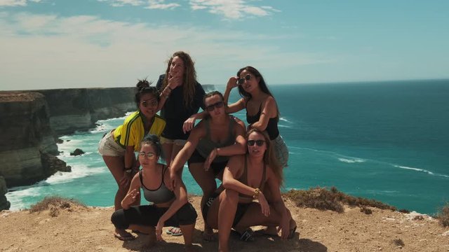 Slow Motion shot of young female group posing during holiday trip with majestic background