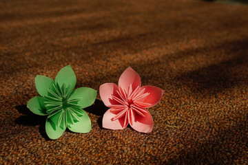 Fototapeta na wymiar beautiful Origami flower blossom. paper flower on textured background. copy space for text concept