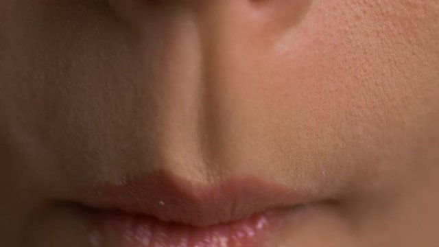Woman bite zephyr and lick her lips, static close up.