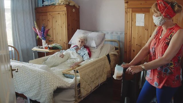 A care worker talks to a patient whilst keeping a safe distance under C019 guidelines
