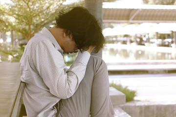 Unemployed stressed young Asian business man with hands on face. Failure and layoff concept.