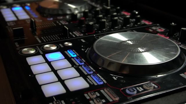 DJ Mixing Music with Digital Controller Turning Knobs