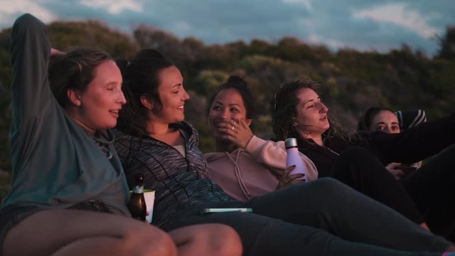 Close up shot of girlfriend group enjoying sunset with drink during trip in Australia