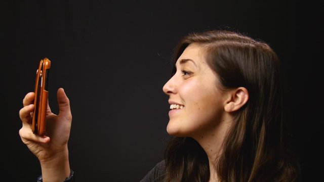 Woman video chats with loved ones, side angle.