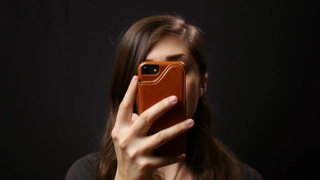 Woman aimlessly scrolls through social media on her phone.