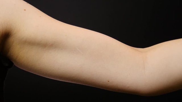 Woman works out her arm with a dumbbell weight.