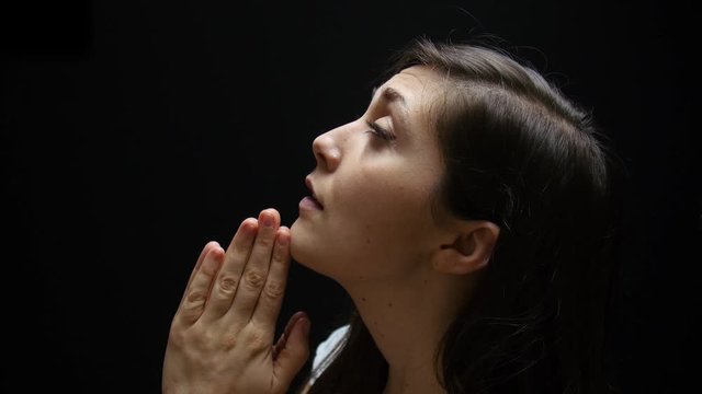 Woman prays to God at night.