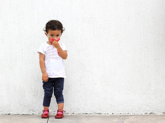 2-year-old Latin girl with protective mask on white wall background, new normal covid-19