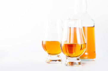 Scotch Whiskey without ice in glasses and bottle, white background, copy space