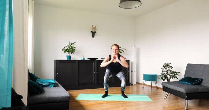 young girl doing her workout at home in the living room - Lunge squat exercise