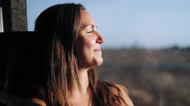 Happy attractive young girl enjoying sunlight during bus drive in Australia,close up