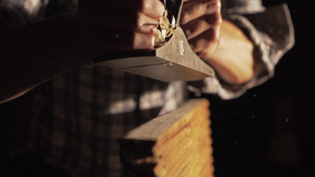 Carpenter slow motion hand planing pine timber shavings ejecting, MID SHOT