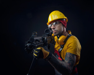 a man in a construction worker's uniform wearing a hard hat with an airsoft weapon in his hands