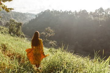 Back view of free Happy Woman Enjoying summer outdoors at Nature with sunlight. Freedom concept in meadow