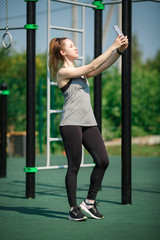 Young Sweet And Pretty Sporty Girl Holding Mobile Phone Taking Selfie Picture In Street Sports Field Smiling Happy Posing Cool in Social Media Self Portrait Concept And Healthy Lifestyle