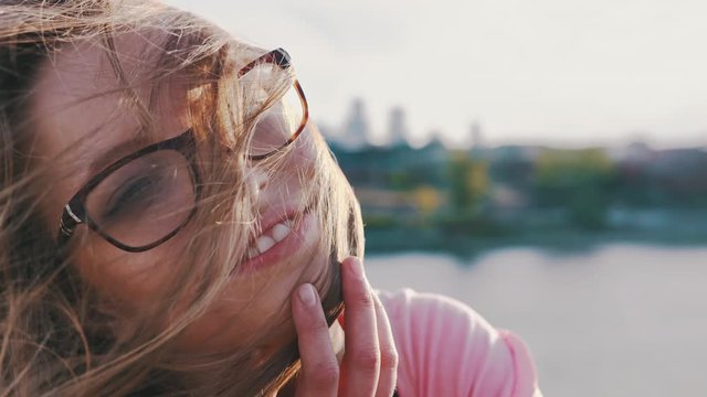 Close up shot of young woman letting the wind blow her hair over her face. Happiness, freedom and face expressions