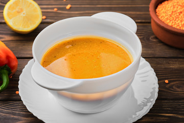 Homemade Turkish lentil soup (Merdzimek Chorbasy). Red lentil soup on a dark wooden table. Healthy and wholesome food. Close up