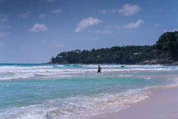 man walking on beach, big waves, beautiful lagoon. Excellent for advertise