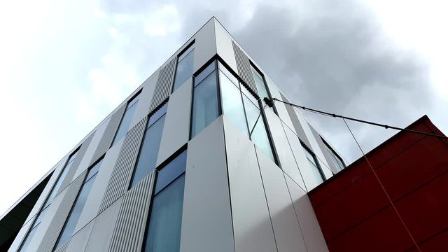 Low angle view commercial window cleaning using modern reach and wash techniques. Water fed pole. 