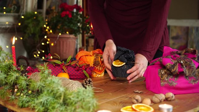 Wrapping gift with fabric and decoration with natural compostable materials. Zero waste holiday season. Sustainable living