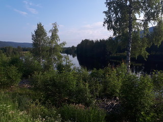 Landscape with the reflection of the sky and trees in the blue water - Rjukan 