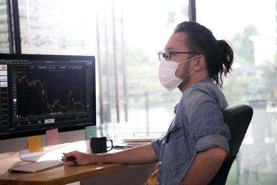  Asian Man Office Worker Wearing Face Mask Working In New Normal Office And Doing Social Distancing During Corona Virus Covid-19 Pandemic