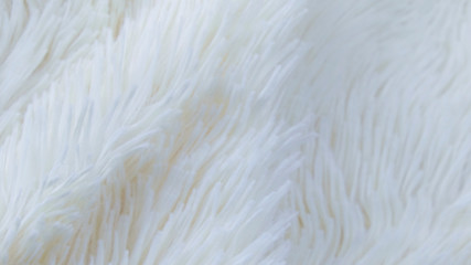 delicate soft background of plush fabric folds on white background. Copy space. Flat lay. loose folds on the fabric of faux fur of lilac color. Details of warm winter clothes