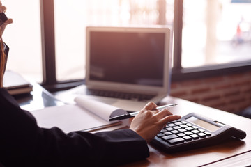 Business women  working with calculator and  business document on office table in office. finance accounting concept.