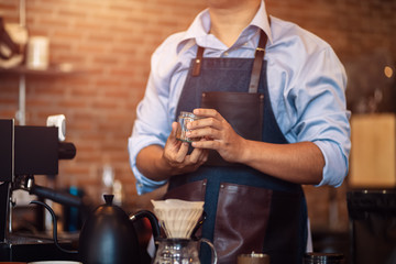 Barista show coffee beans in drip glass.