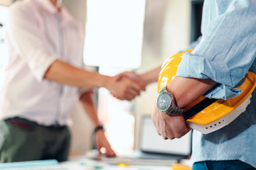 architect hold safety helmet. Blur architect, Engineer and businessman handshake after meeting...