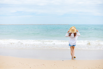 Fototapeta na wymiar Happy young girl walking on the beach. Summer travel, vocation, holiday concept.