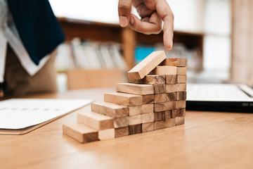 Ant eye view Male hand stacking wooden blocks. Business development and growth concept