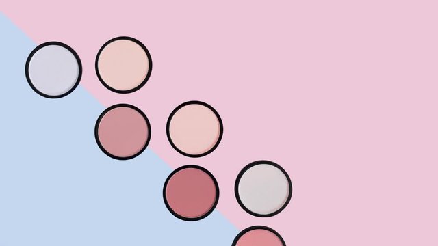 Beige blush, brown eye shadows and compact face powder on pastel pink and blue background. Trendy colors. Makeup. Cosmetic products. Tonal foundation. Beauty pattern. Stop motion animation. Place text