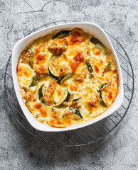 Zucchini, chicken, mozzarella cheese baked casserole on a grey background, top view. Delicious lunch