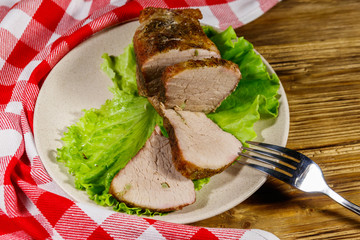 Tasty baked pork with spices on a wooden table