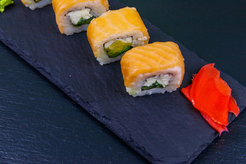 Sushi rolls Philadelphia on a black slate