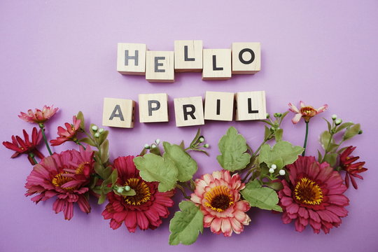 Hello April alphabet letters with pink flower decoration on purple background