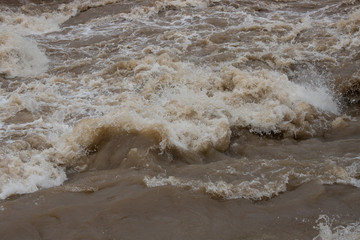 夏の豪雨で氾濫している川の様子