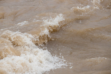 夏の豪雨で氾濫している川の様子