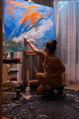 Famous woman artist working on impressionism painting in art workshop. Modern artwork paint on...