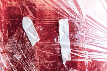 Plastic films on a red wooden board.