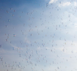 Soap bubbles fly in the blue sky