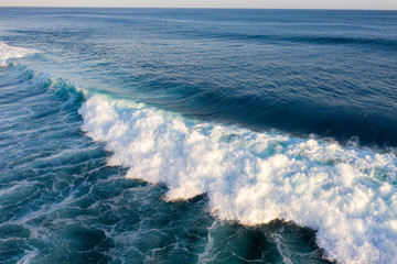 Aerial view of giant ocean waves crashing and foaming