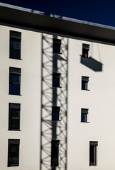 Shadow of a Construction Crane on a Modern Facade Building in Switzerland.