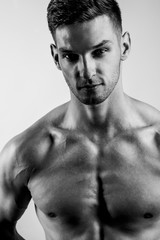 Fototapeta premium Male beauty concept. Portrait of a shirtless handsome young man with stylish haircut posing over gray background. Close up. Studio shot
