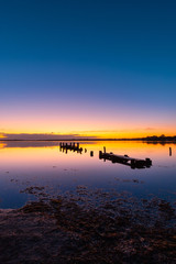 A broken wooden pier on the lake at dawn, Gorokan, Australia.